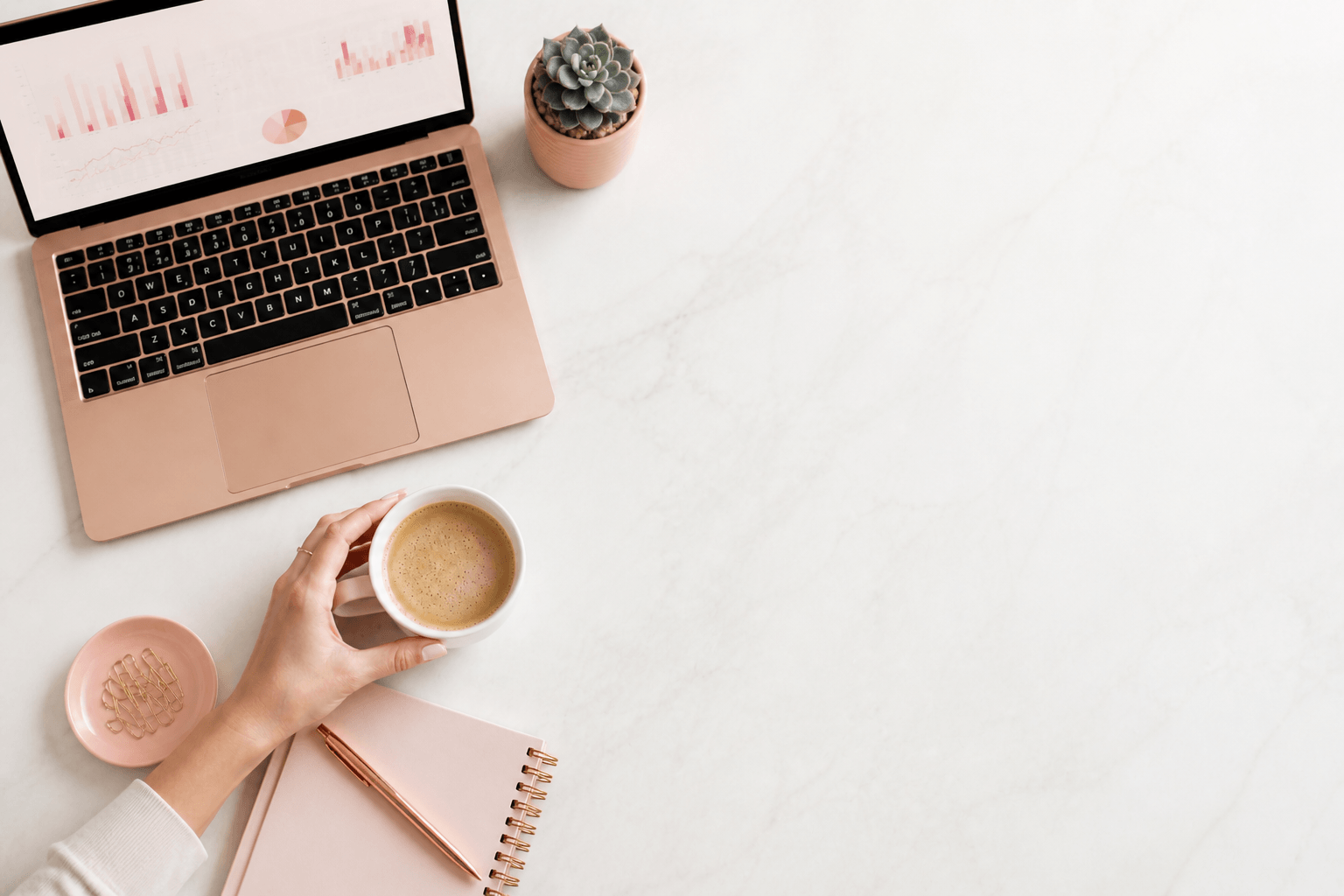 Modern business owner workspace with laptop showing analytics dashboard and coffee on a clean desk
